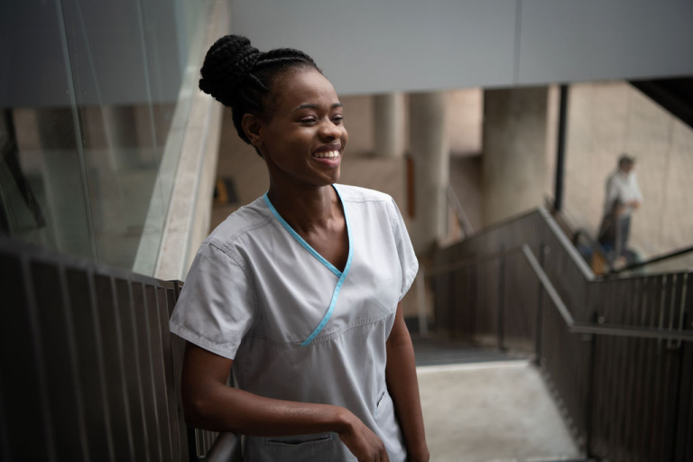 CDU nursing student Fifi Giraneza smiling, standing on a set of stairs