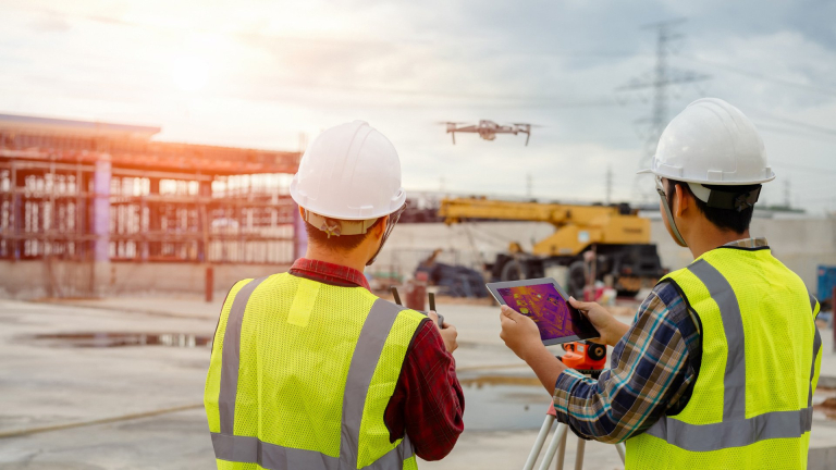 Industrial workers flying a drone on a worksite