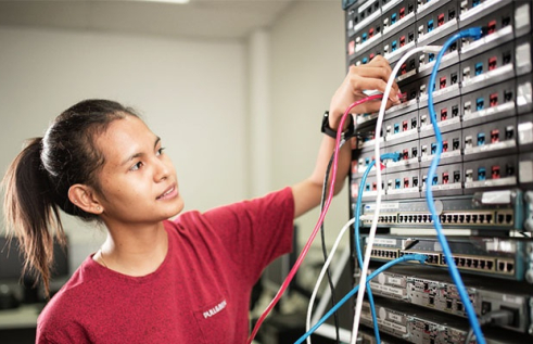 Female CDU IT student working on a switchboard