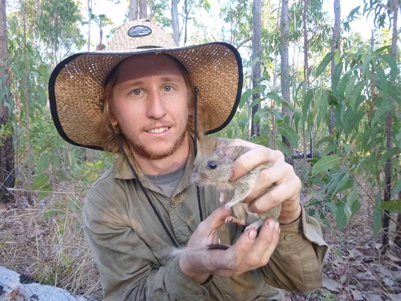Small mammal researcher Hugh Davies holds a brush tailed rabbit rat.