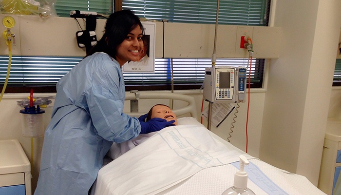 Ishita in a clinical sim block with a training dummy 