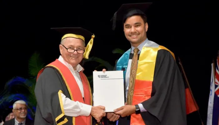Mark Munnich holding his graduation certificate