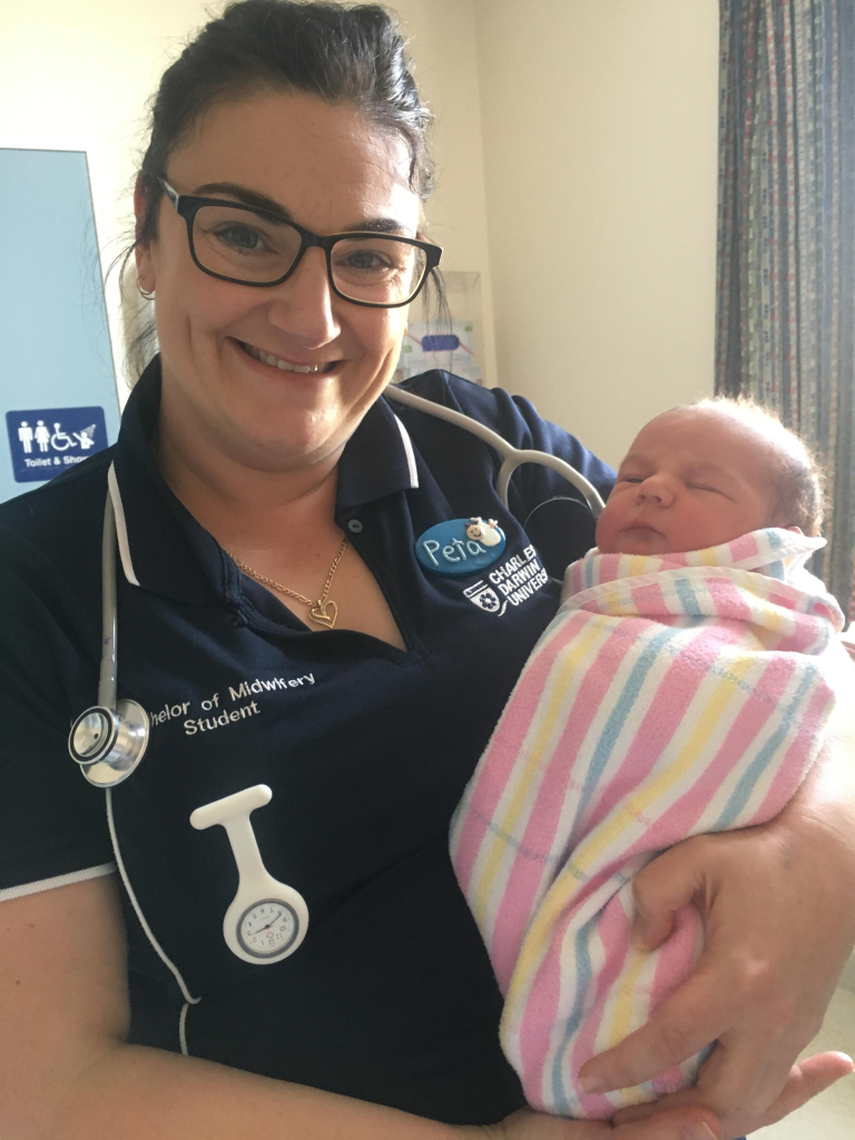 CDU student and midwife-in-training Peta Lewellin holds a newborn baby