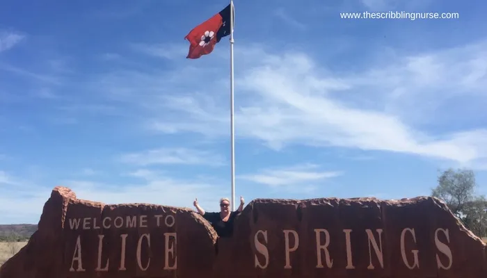 Rachel Ashton standing in from of a welcome to Alice Springs Sign