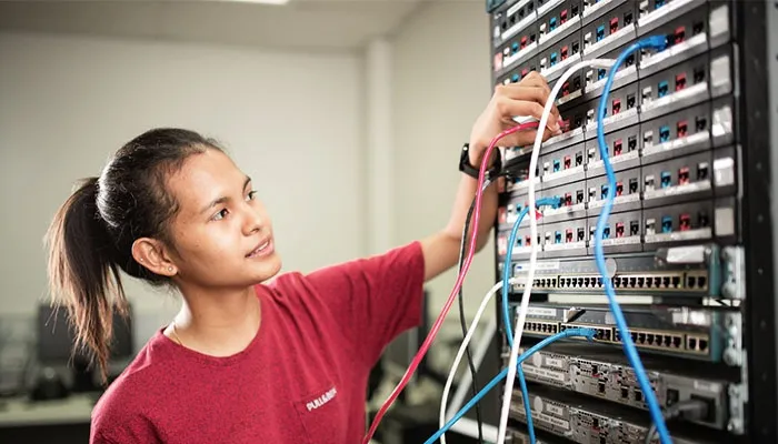 Female CDU IT student working on a switchboard