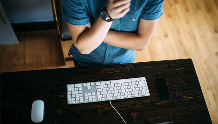 Person standing by keyboard and desk