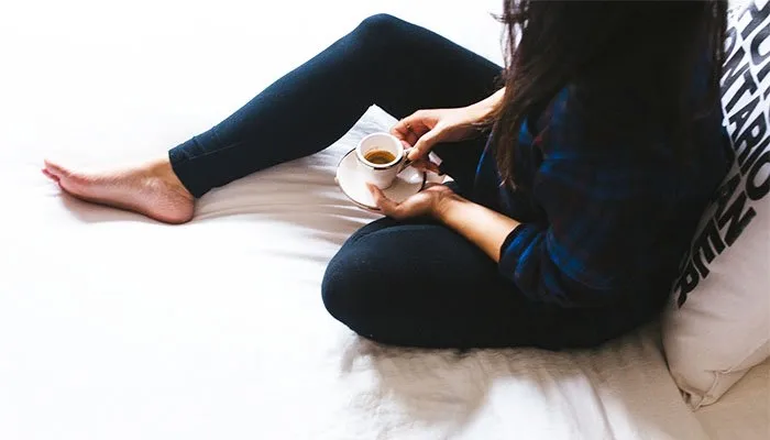 Lady with coffee on bed