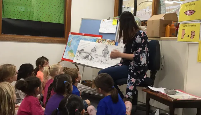 Sallie reading a book to the kids in her classroom