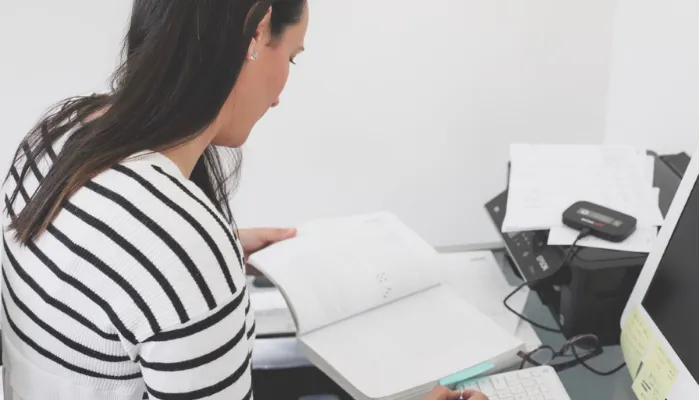 Sallie in her study space reading a textbook