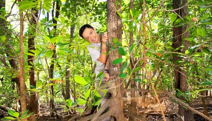 CDU student Sigit Sasmito smiling from behind a tree