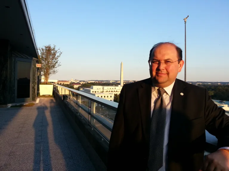 Emre smiling in front of a view of the Washington Monument