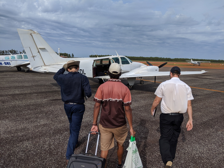 Walking towards a small plane on a remote runway