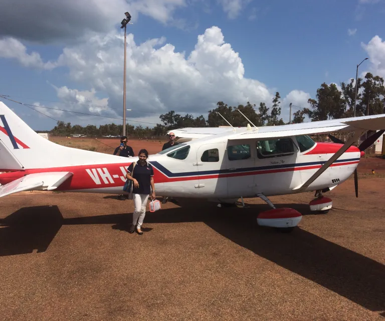 Athira standing in front of a helicopter in a remote community