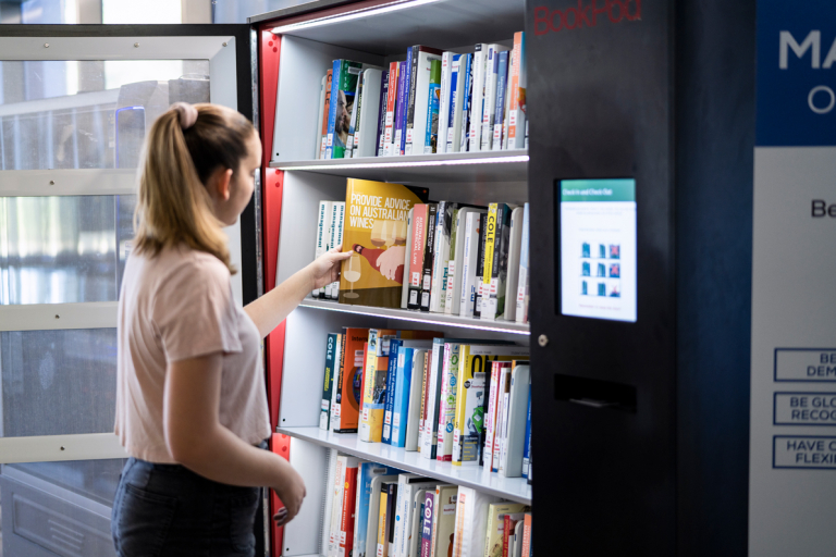 CDU student Zoe White using a book vending machine