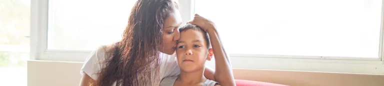 Woman kissing child on forehead