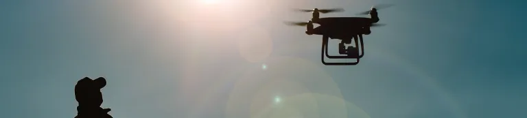 Man with cap watching drone