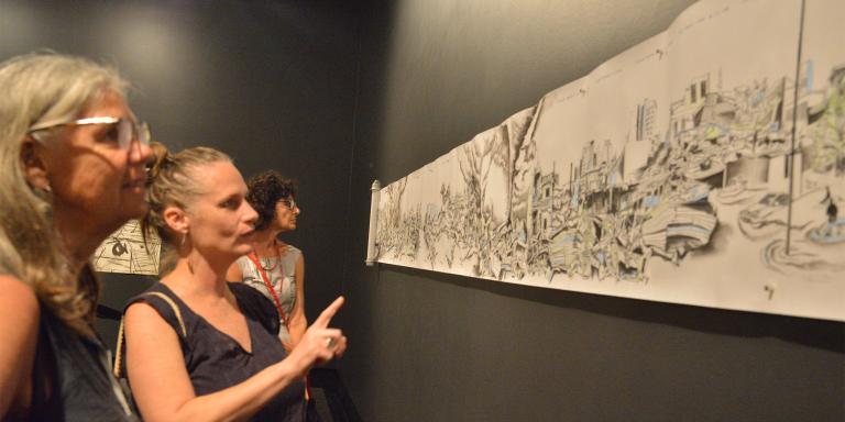 Gallery visitors view a drawing by Winsome Jobling, A year of natural disasters, 2011