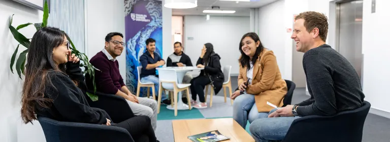 A group of students sitting around a table at Sydney campus
