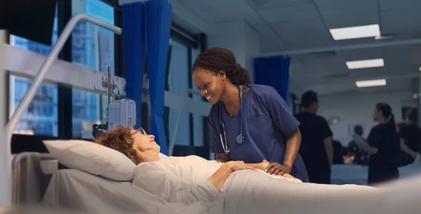 a nursing student in Sydney checking over a patient in bed  