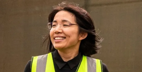 Dr Jady Li, head and shoulders, wearing hi-vis vest, with brown background