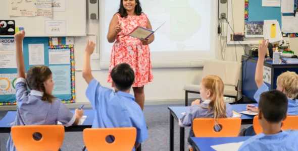 Indigenous woman teaches children in a classroom