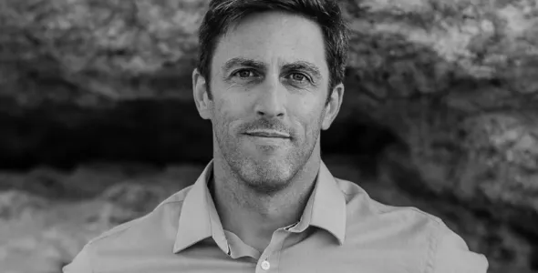Author Russell Marks against rockface in black and white