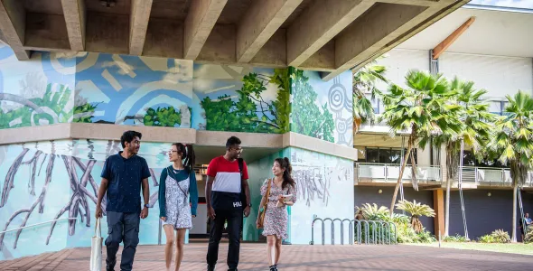 Four students walking around the Casuarina campus