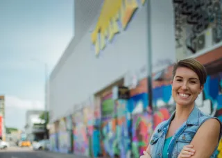 Smiling woman in front of graffiti