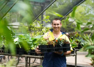 Student holding a tray of plants