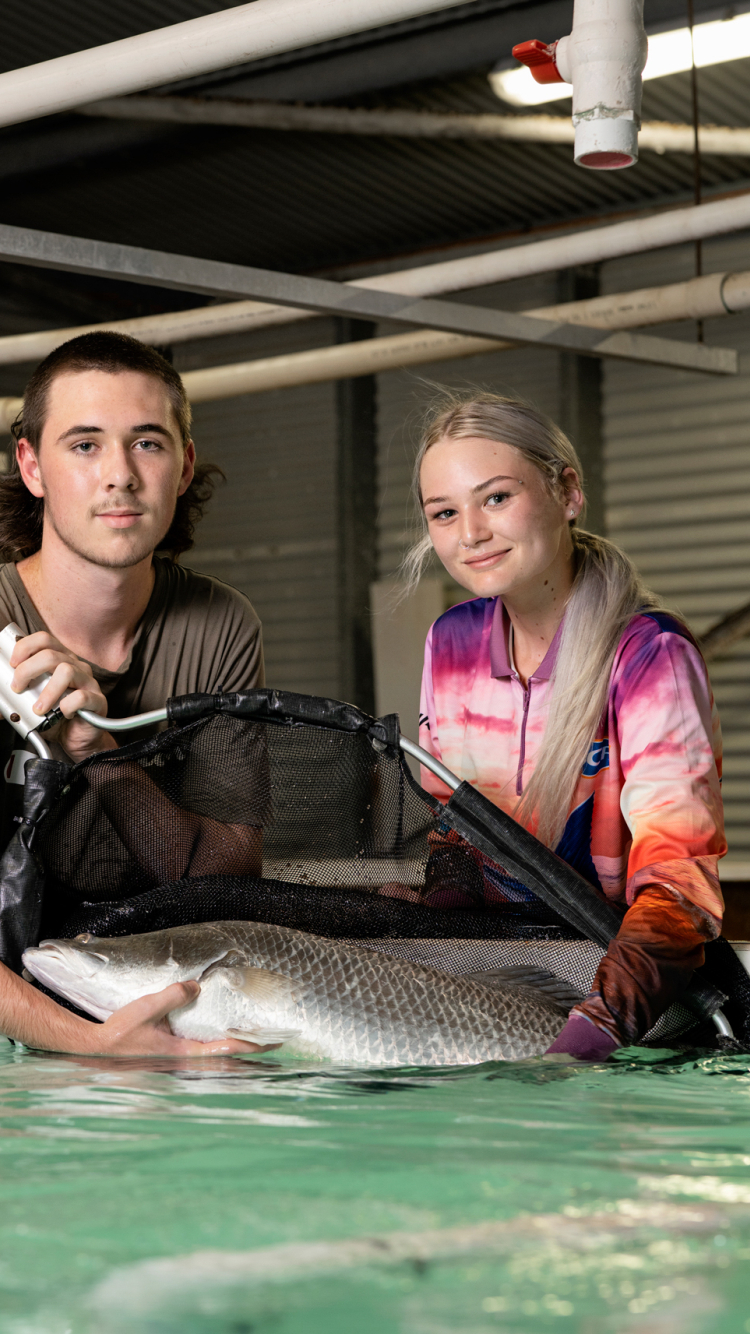 Aquaculture students holding a fish
