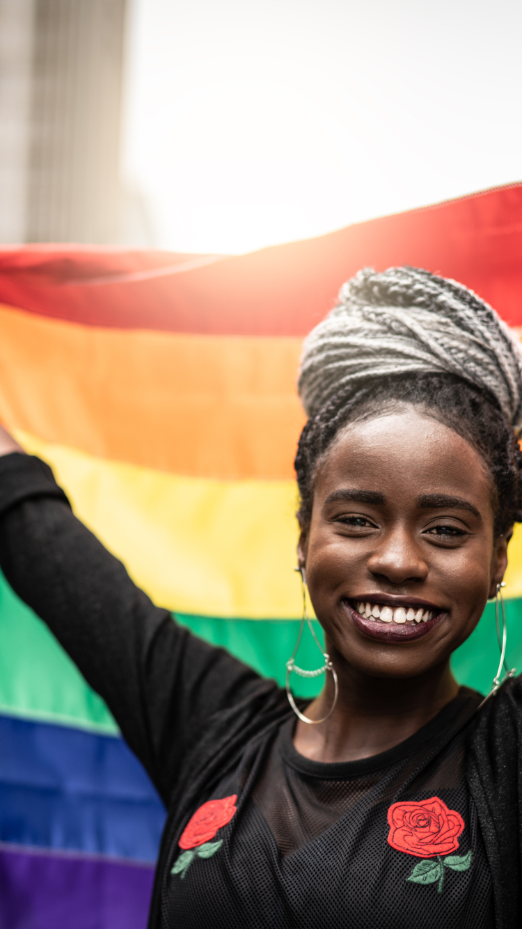 African american woman holding a pride flag 