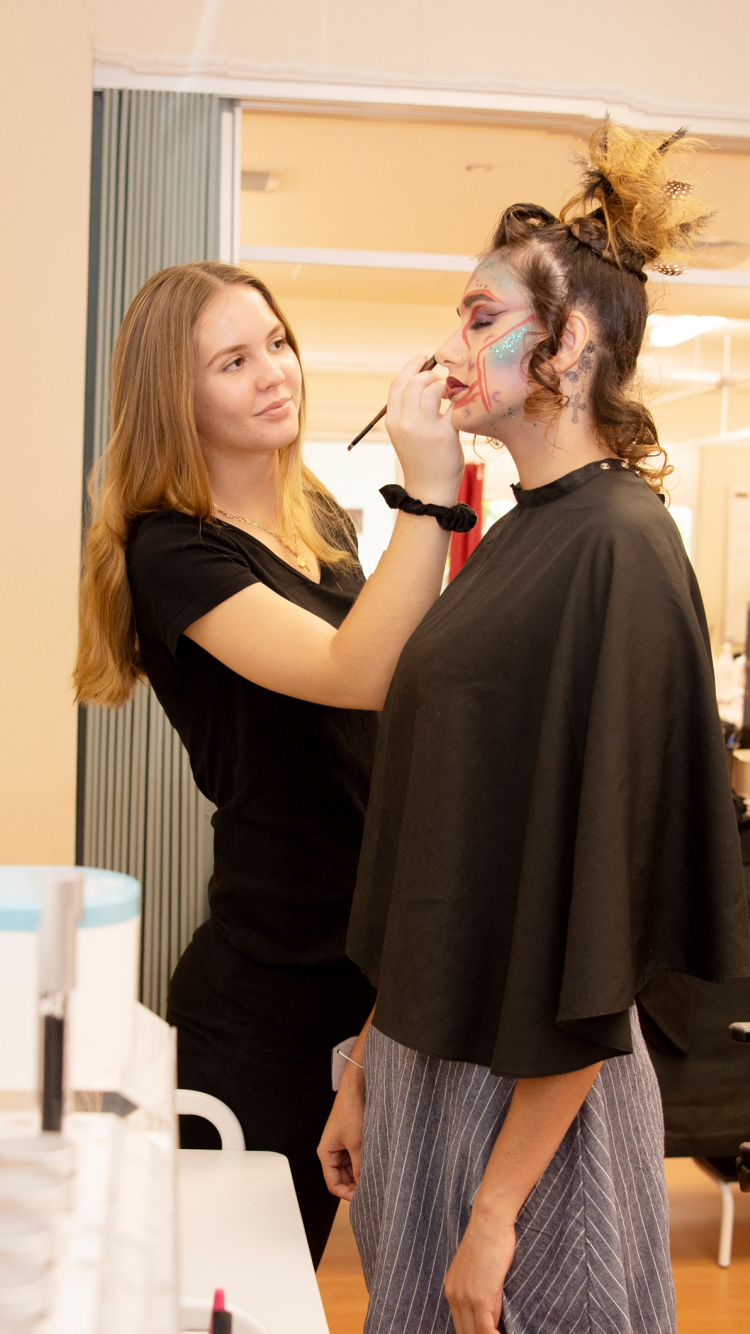 CDU hair and beauty student applying makeup on client