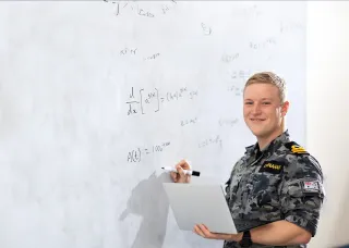 Defence student in front of whiteboard