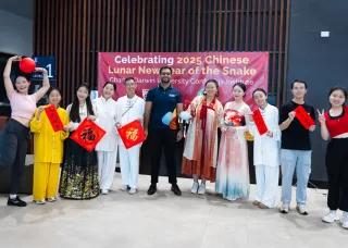 Group of people posing with Chinese decorations and signs