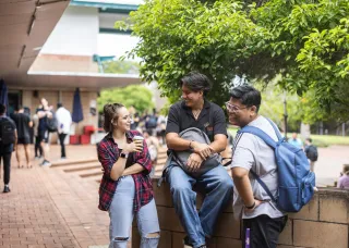 Group of three students interacting on the Casuarina campus