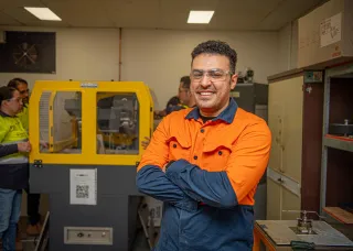 Man in high vis gear looking at the camera with arms crossed