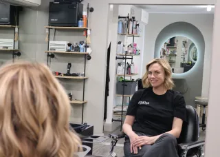 Esme sits in barbering chair