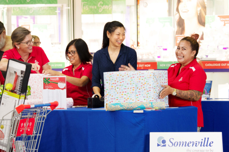 Dr Buaphrao Raphiphatthana helping to wrap Christmas presents with Somerville volunteers at a local shopping centre.uare.