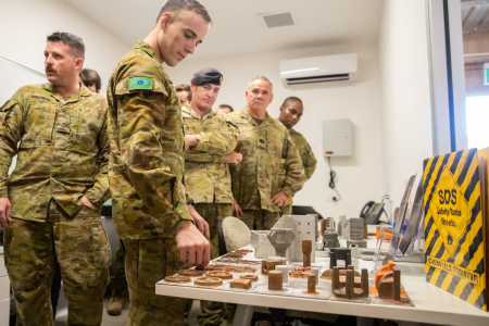 Australian Army soldiers check out the parts created using 3D printing technology.
