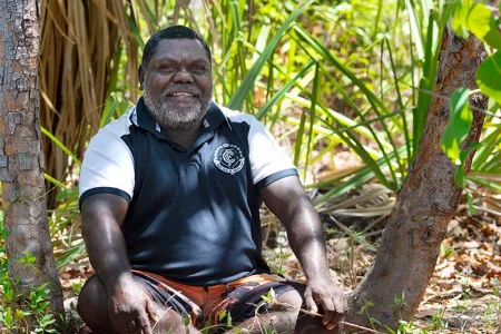 Stephen Dhamarrandji pictured sitting among native bush lands.