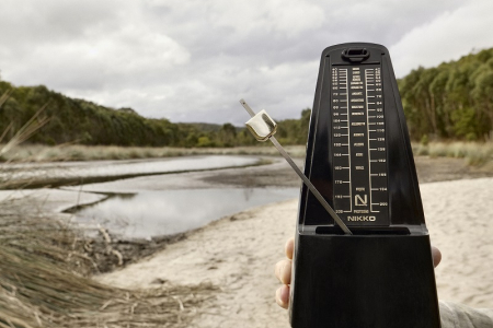 Image of metronome on a landscape background