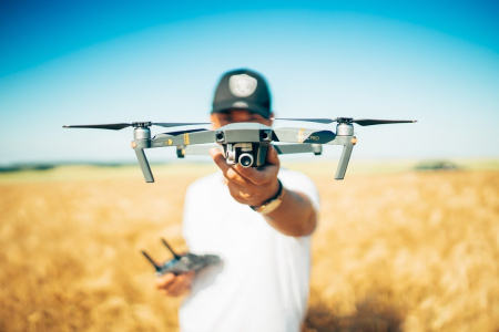 Image of a man holding a drone up in front of his face