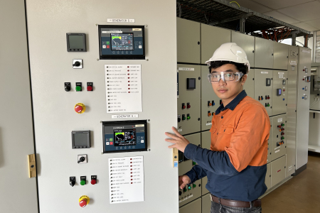 engineer in a safety west opening the control system power panel
