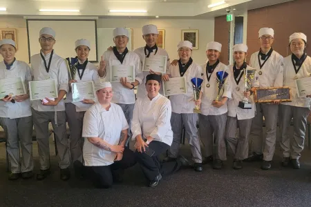 Competitors and judges pose with certificates