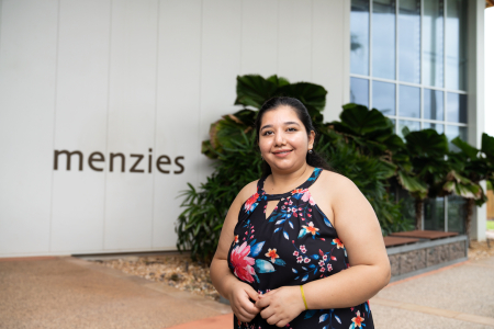 Woman standing in front of building with 'Menzies' name 