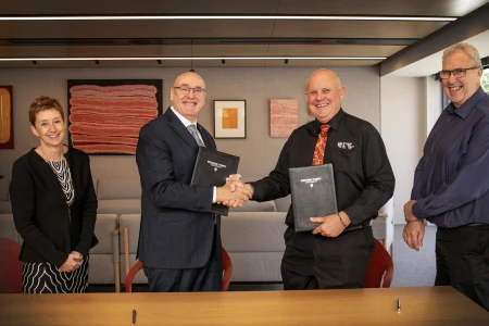 two men shaking hands in boardroom