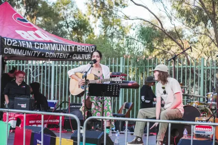 singer with guitar and drummer on stage