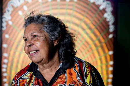 First Nations women smiling in front of Indigenous Art