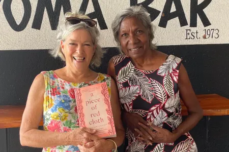 Co-authors Leonie Norrington and Merrkiyawuy Ganambarr-Stubbs smiling and holding their book