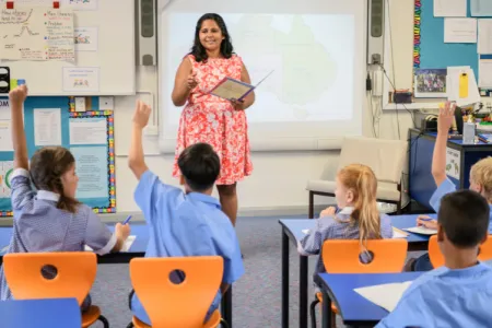 Indigenous woman teaches children in a classroom